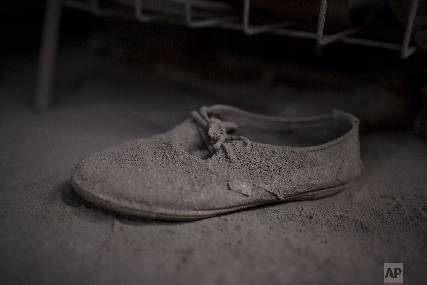  This June 9, 2018 photo shows a shoe caked with volcanic ash spewed by the Volcan de Fuego or Volcano of Fire, inside a home in San Miguel Los Lotes, Guatemala. (AP Photo/Rodrigo Abd) 