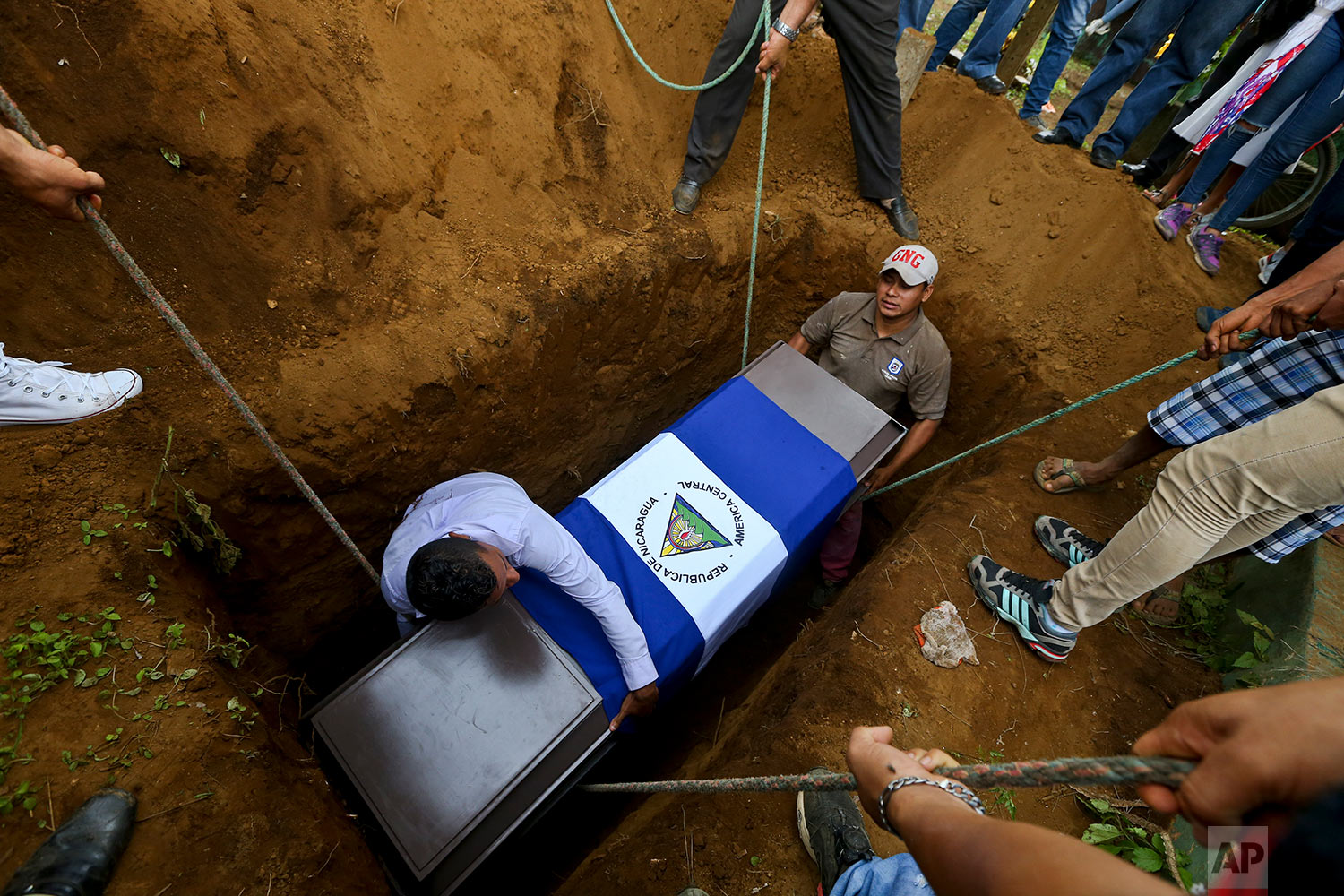  In this May 25, 2018 photo, people lower the coffin of Manuel de Jesus Chavez, 38, at the cemetery in Leon, Nicaragua. Chavez, 38, died during clashes with police as anti-government protesters blocked the Panamerican Highway. (AP Photo/Esteban Felix