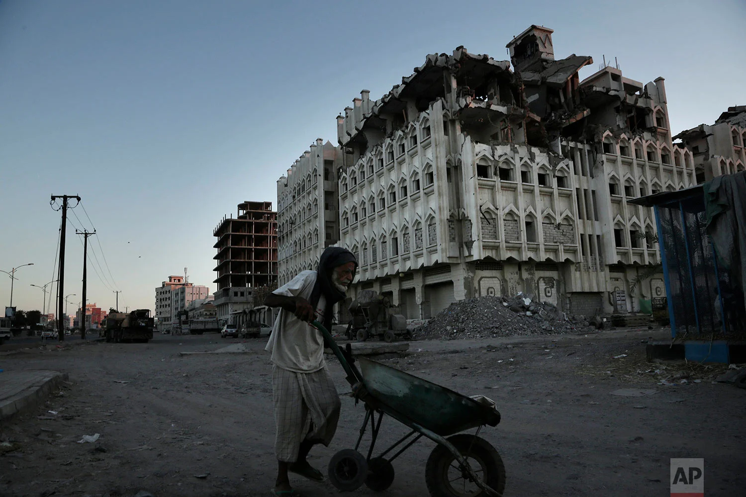 A elderly man walks past a damaged building from the 2015 war in Aden, Yemen. (AP Photo/Nariman El-Mofty)