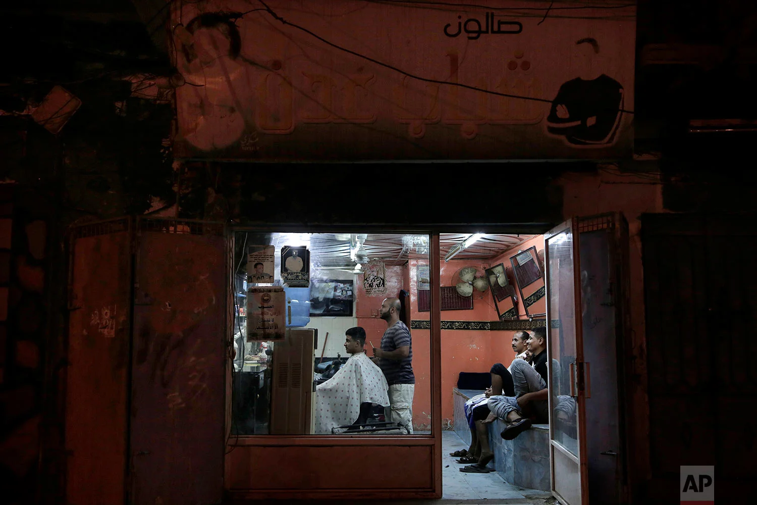 18-year-old Abdullah gets his hair cut at a barbershop in Aden, Yemen. (AP Photo/Nariman El-Mofty)
