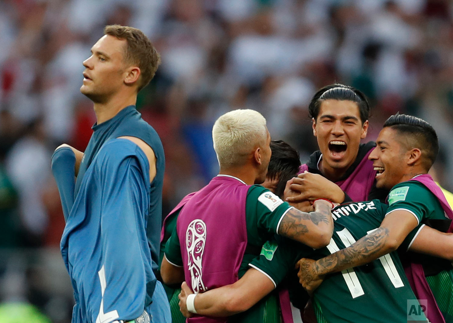  Germany goalkeeper Manuel Neuer walks past as Mexico players celebrate after defeating Germany 1-0 in their group F match at the 2018 soccer World Cup in the Luzhniki Stadium in Moscow, Russia, Sunday, June 17, 2018. (AP Photo/Eduardo Verdugo) 