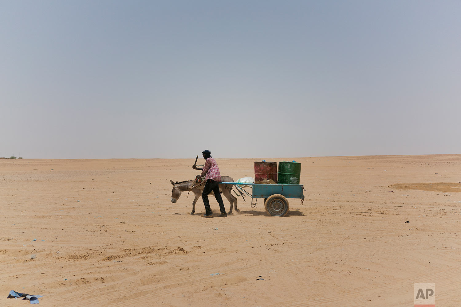  A man and his donkey transport water barrels toward the Algerian border in Niger's Tenere desert region of the south central Sahara on June 3, 2018. (AP Photo/Jerome Delay) 