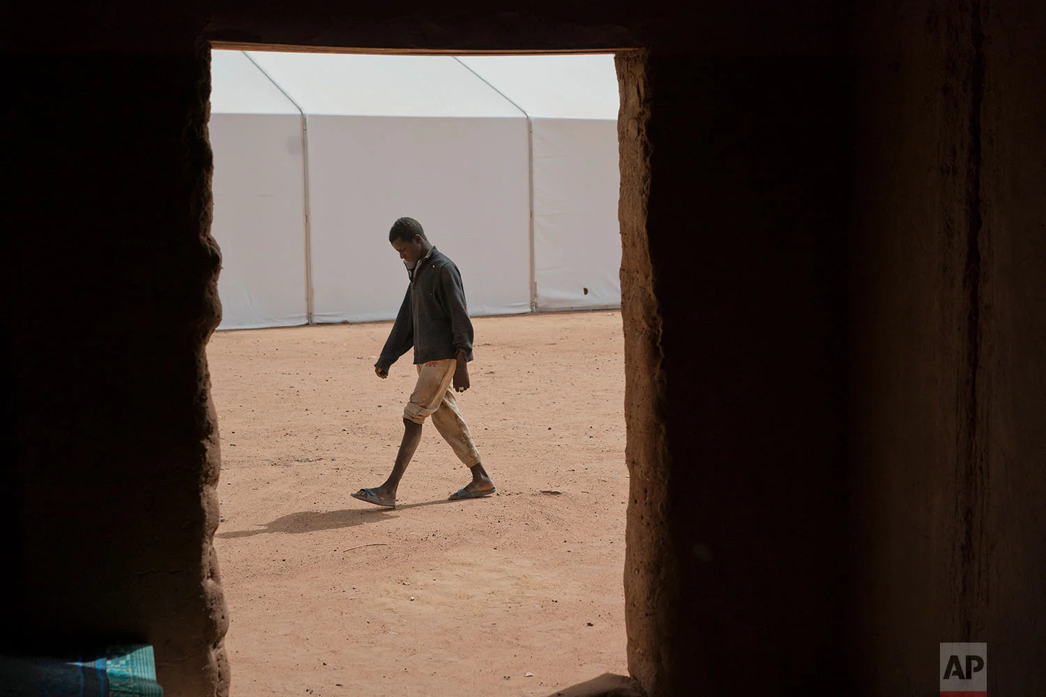 A young migrant who has been expelled from Algeria stands in a transit center in Arlit, Niger, on June 2, 2018. (AP Photo/Jerome Delay)