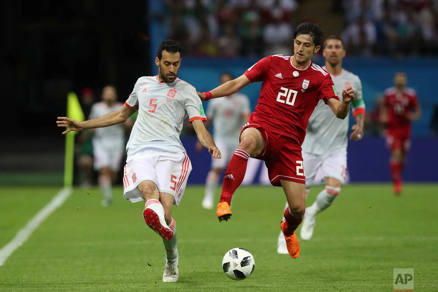 Spain's Sergio Busquets, left, fights for the ball with Iran's Sardar Azmoun during the group B match between Iran and Spain at the 2018 soccer World Cup in the Kazan Arena in Kazan, Russia, Wednesday, June 20, 2018. (AP Photo/Thanassis Stavrakis)