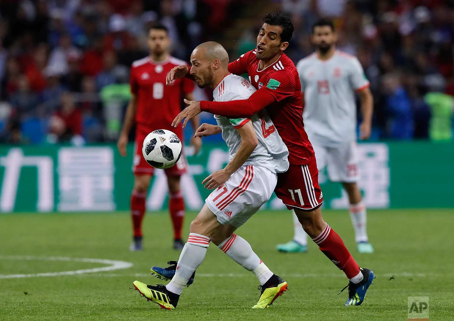 Spain's David Silva, left, fights for the ball with Iran's Vahid Amiri during the group B match between Iran and Spain at the 2018 soccer World Cup in the Kazan Arena in Kazan, Russia, Wednesday, June 20, 2018. (AP Photo/Manu Fernandez)