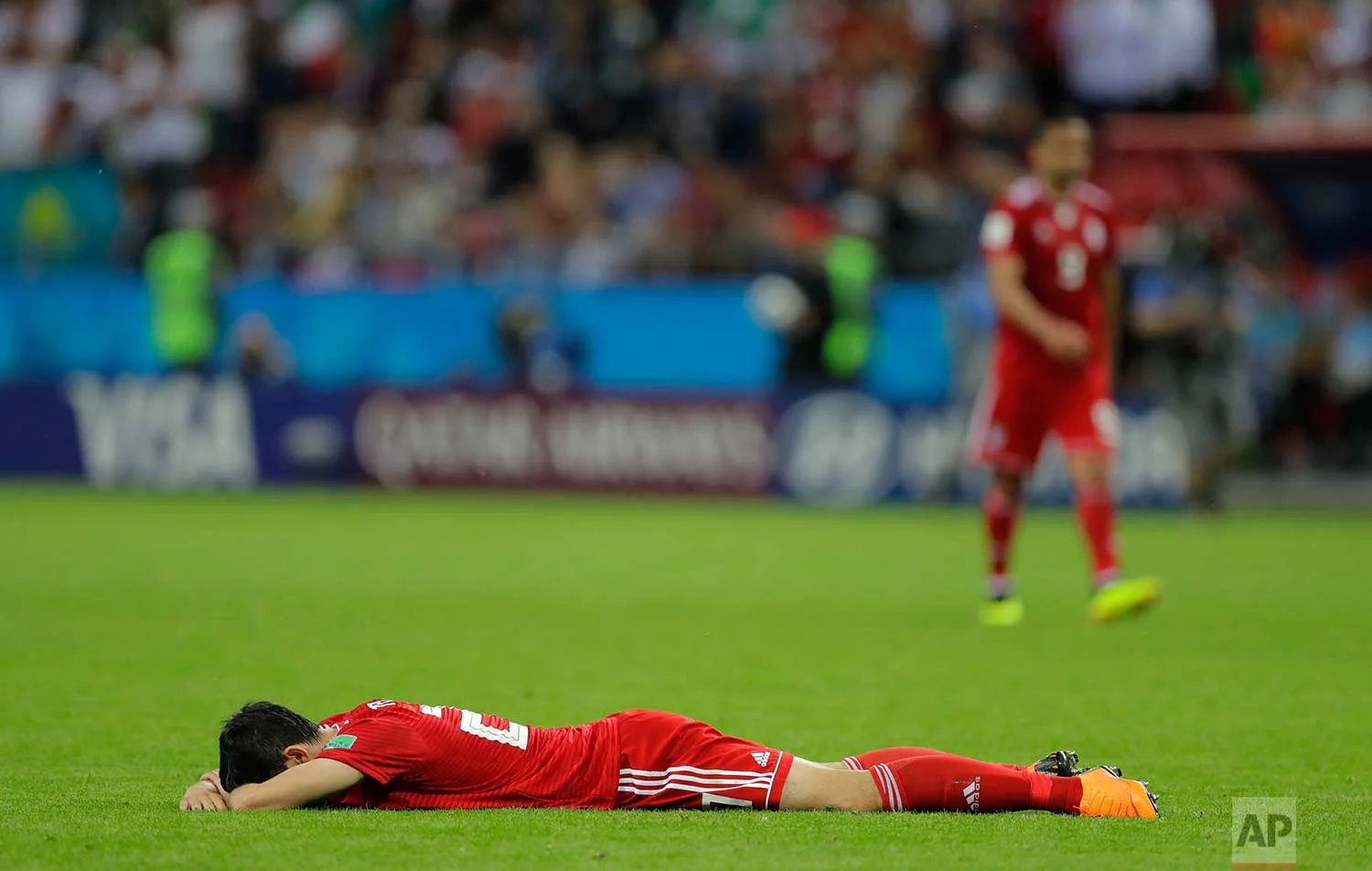 Iran's Sardar Azmoun lies flat out on the ground after the end of the group B match between Iran and Spain at the 2018 soccer World Cup in the Kazan Arena in Kazan, Russia, Wednesday, June 20, 2018. Spain won the game 1-0. (AP Photo/Sergei Grits)