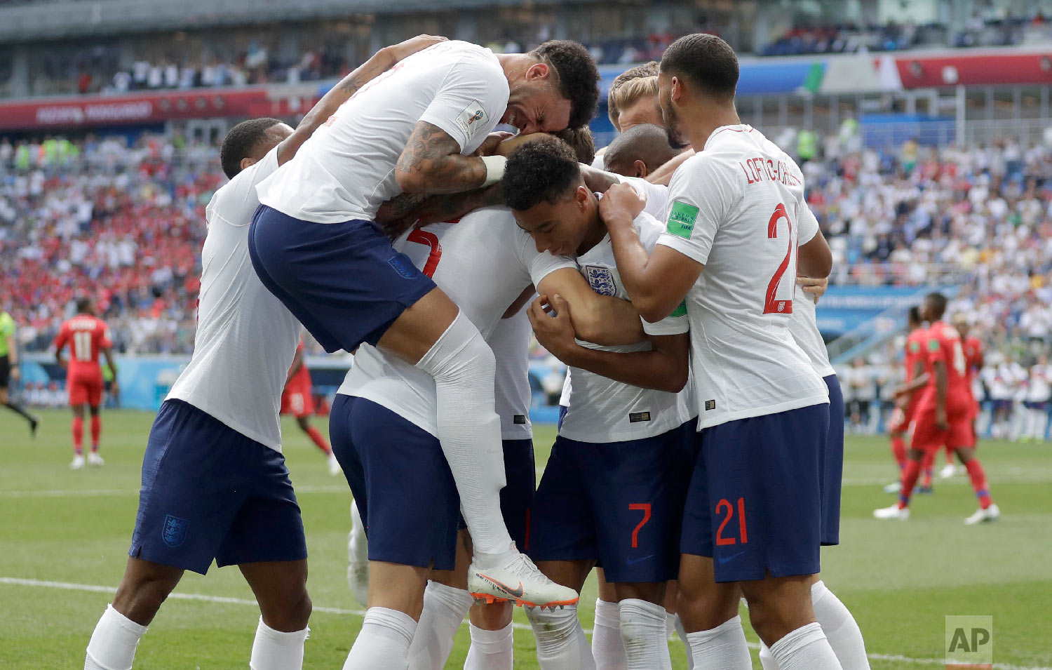 England players run to teammate John Stones after he scored his team's first goal during the group G match between England and Panama at the 2018 soccer World Cup at the Nizhny Novgorod Stadium in Nizhny Novgorod , Russia, Sunday, June 24, 2018. (AP Photo/Matthias Schrader)