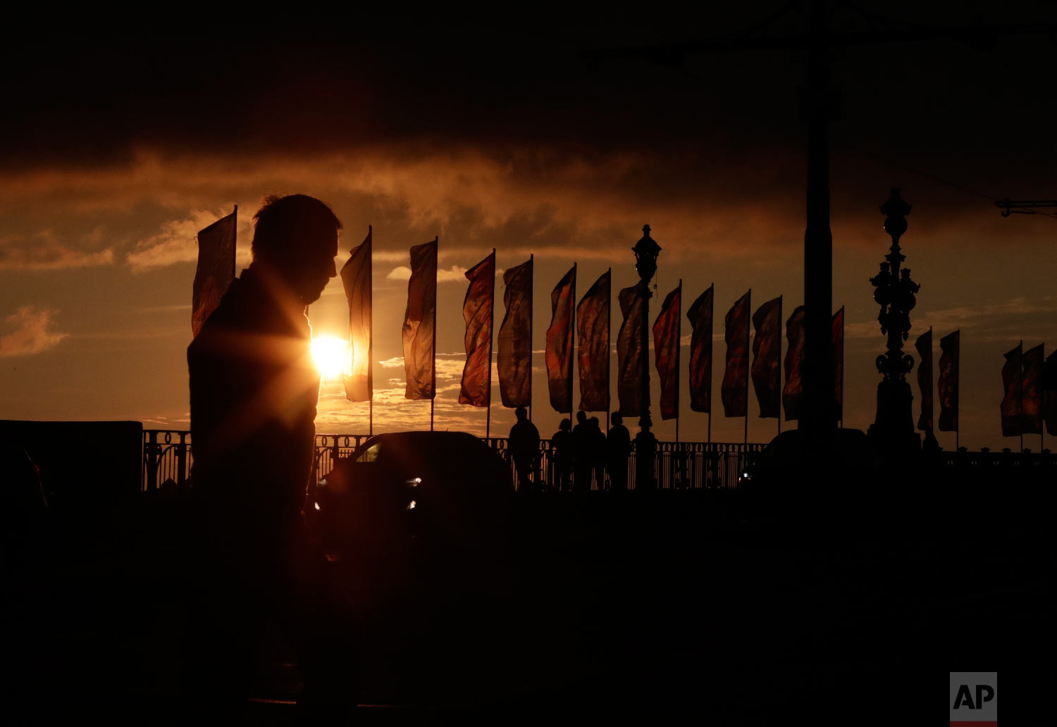  Visitors and banners for the 2018 soccer World Cup are silhouetted in St. Petersburg, Russia on June 24, 2018. (AP Photo/Lee Jin-man) 