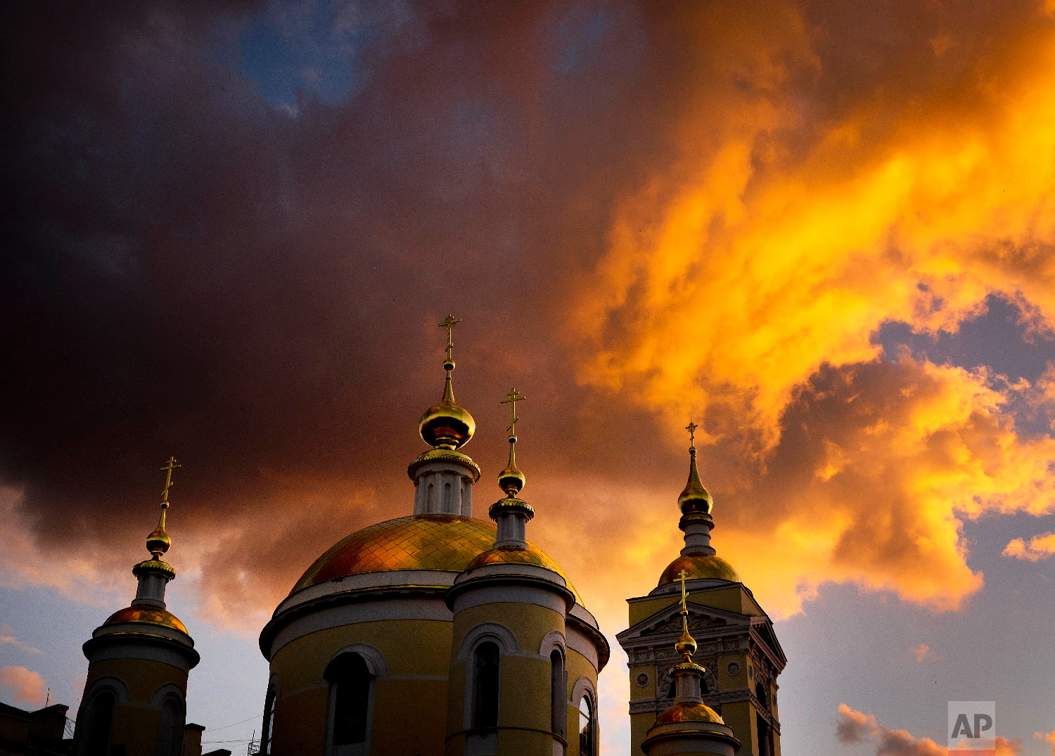  Clouds are illuminated by the sun setting sun over a church during the 2018 soccer World Cup in Podolsk near Moscow, Russia on June 19, 2018. (AP Photo/Michael Probst) 