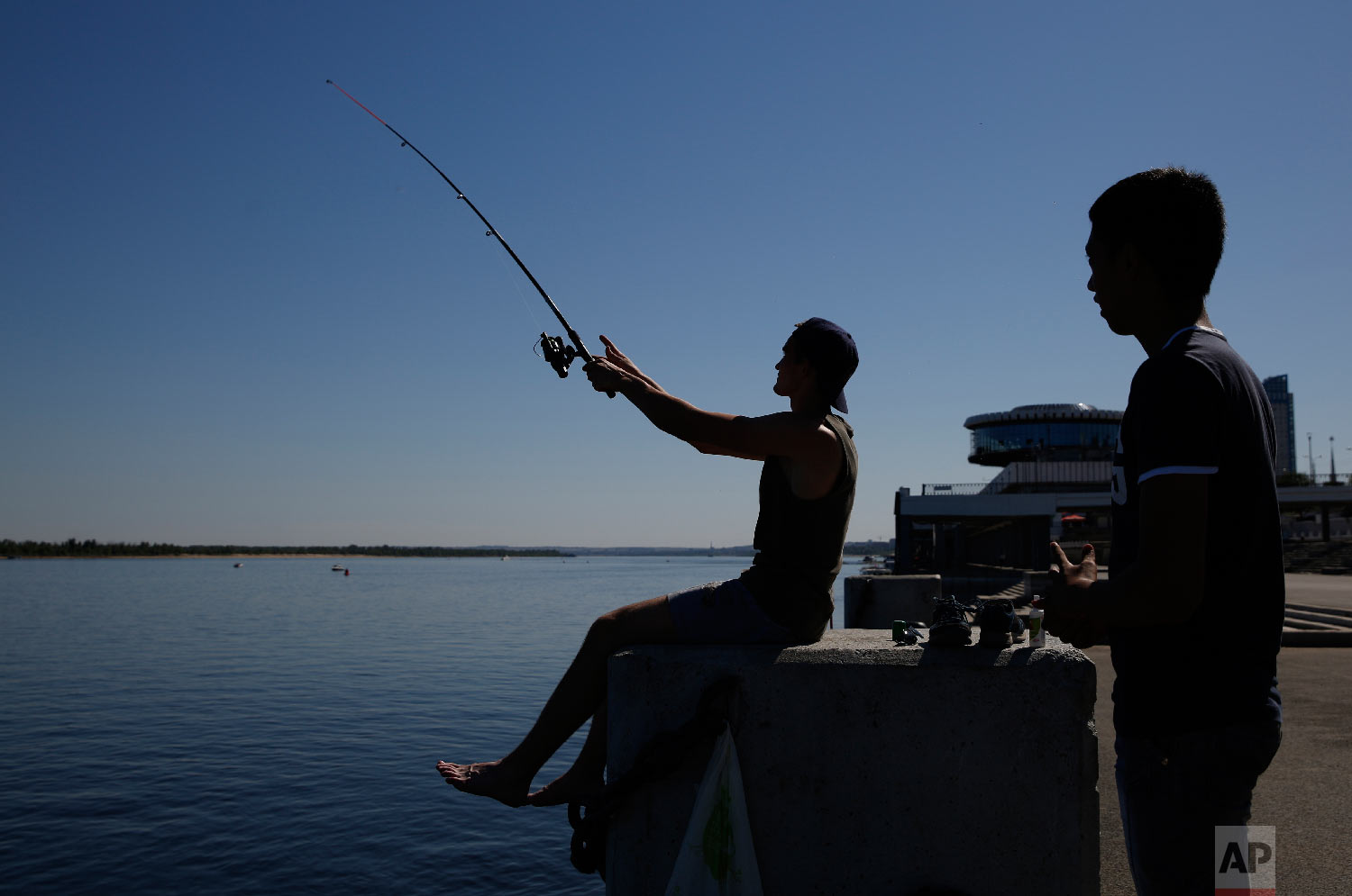 Young men fish along the banks of the Volga River during the 2018 soccer World Cup in Volgograd, Russia on June 18, 2018. (AP Photo/Rebecca Blackwell)