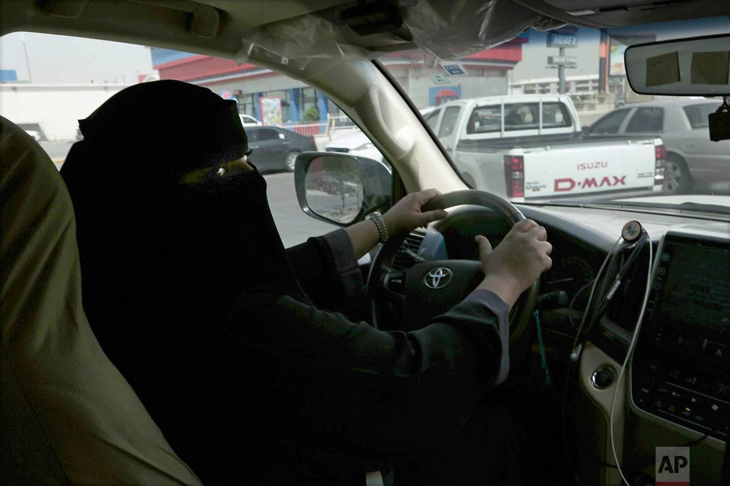 Mabkhoutah al-Mari drives to work for the first time in Riyadh, Saudi Arabia, Sunday, June 24, 2018. "It feels beautiful. It was a dream for us so when it happens in reality, I am between belief and disbelief -- between a feeling of joy and astonishment," said Mari as she pulled up to order a drive-thru coffee on her way to work. (AP Photo/Nariman El-Mofty)