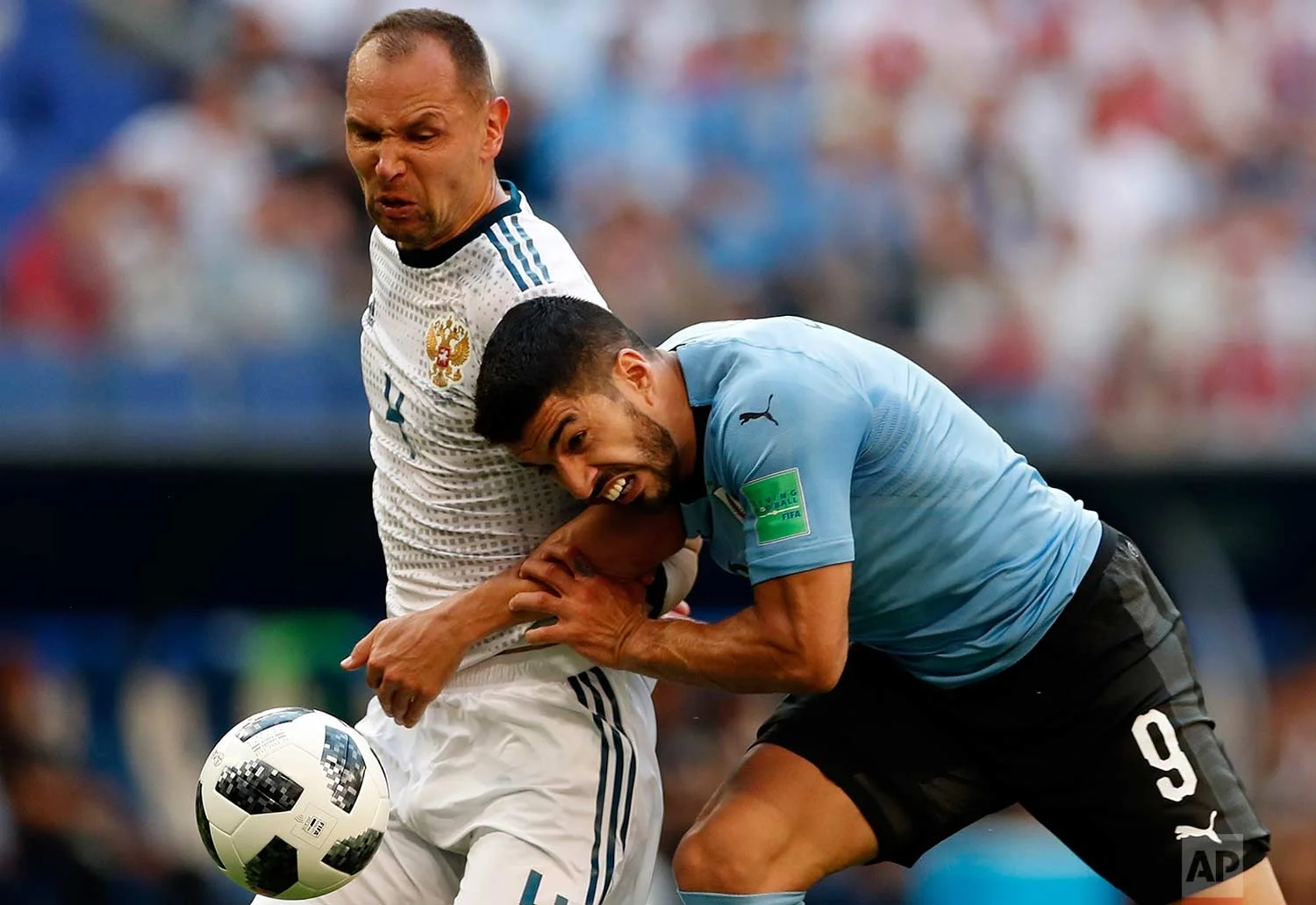 Uruguay's Luis Suarez, right, and Russia's Sergei Ignashevich fight for the ball during the group A match between Uruguay and Russia at the 2018 soccer World Cup at the Samara Arena in Samara, Russia, Monday, June 25, 2018. (AP Photo/Rebecca Blackwell)