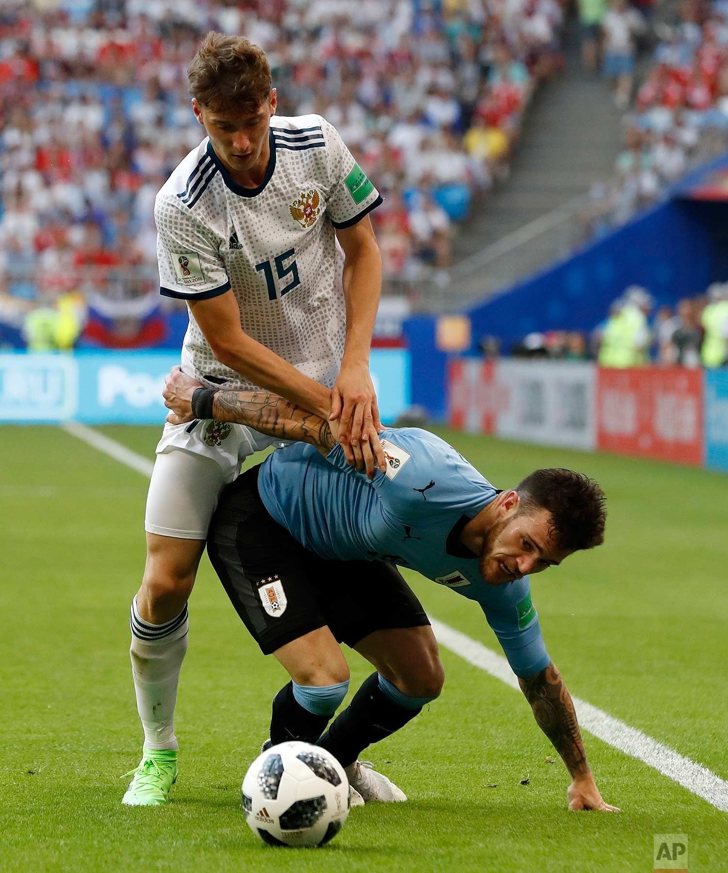  Russia's Alexei Miranchuk, left, stops Uruguay's Nahitan Nandez during the group A match between Uruguay and Russia at the 2018 soccer World Cup at the Samara Arena in Samara, Russia, Monday, June 25, 2018. (AP Photo/Rebecca Blackwell) 