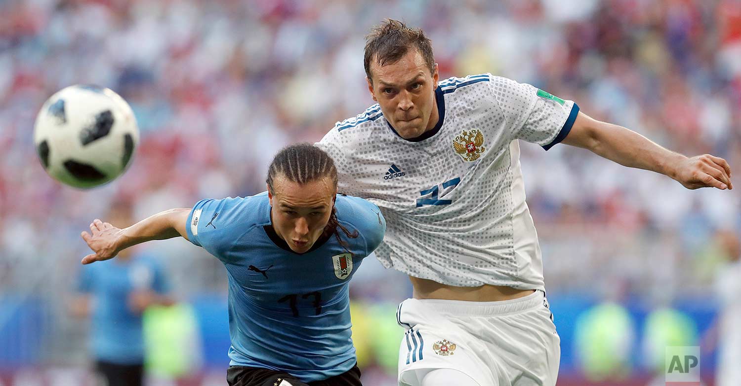 Uruguay's Diego Laxalt, left, and Russia's Artyom Dzyuba challenge for the ball during the group A match between Uruguay and Russia at the 2018 soccer World Cup at the Samara Arena in Samara, Russia, Monday, June 25, 2018. (AP Photo/Hassan Ammar) 