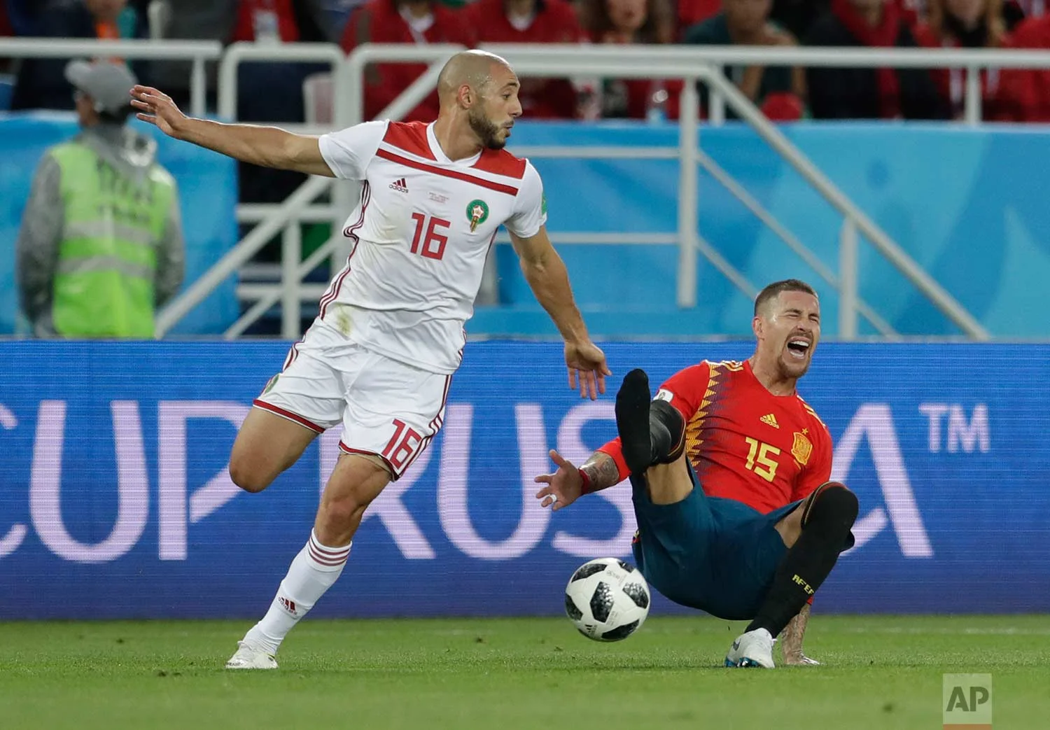 Spain's Sergio Ramos, right falls, loosing his shoe after a tackle by Morocco's Noureddine Amrabat, left, during the group B match between Spain and Morocco at the 2018 soccer World Cup at the Kaliningrad Stadium in Kaliningrad, Russia, Monday, June 25, 2018. (AP Photo/Petr David Josek)
