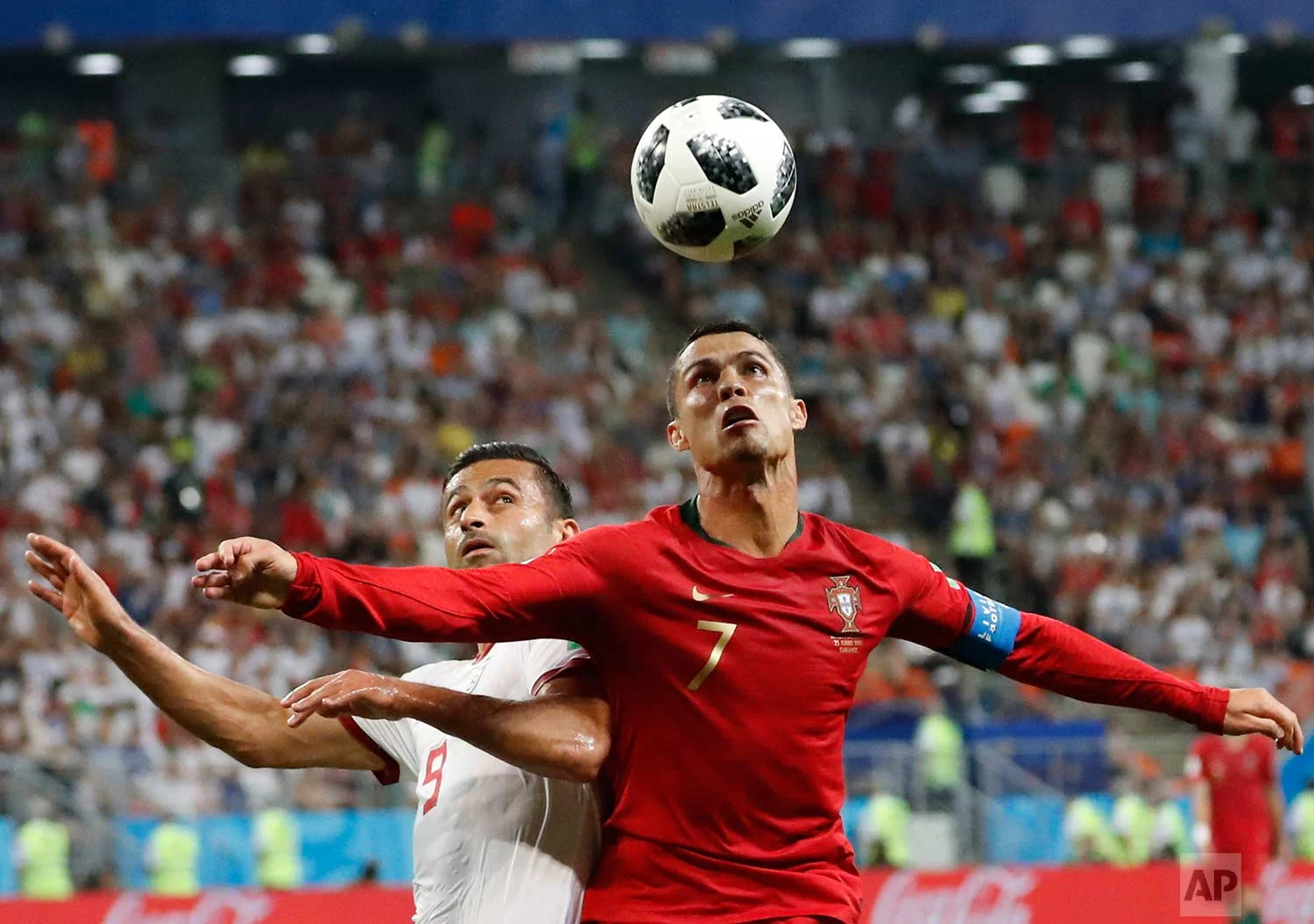 Portugal's Cristiano Ronaldo, right, and Iran's Omid Ebrahimi challenge for the ball during the group B match between Iran and Portugal at the 2018 soccer World Cup at the Mordovia Arena in Saransk, Russia, Monday, June 25, 2018. (AP Photo/Pavel Golovkin)