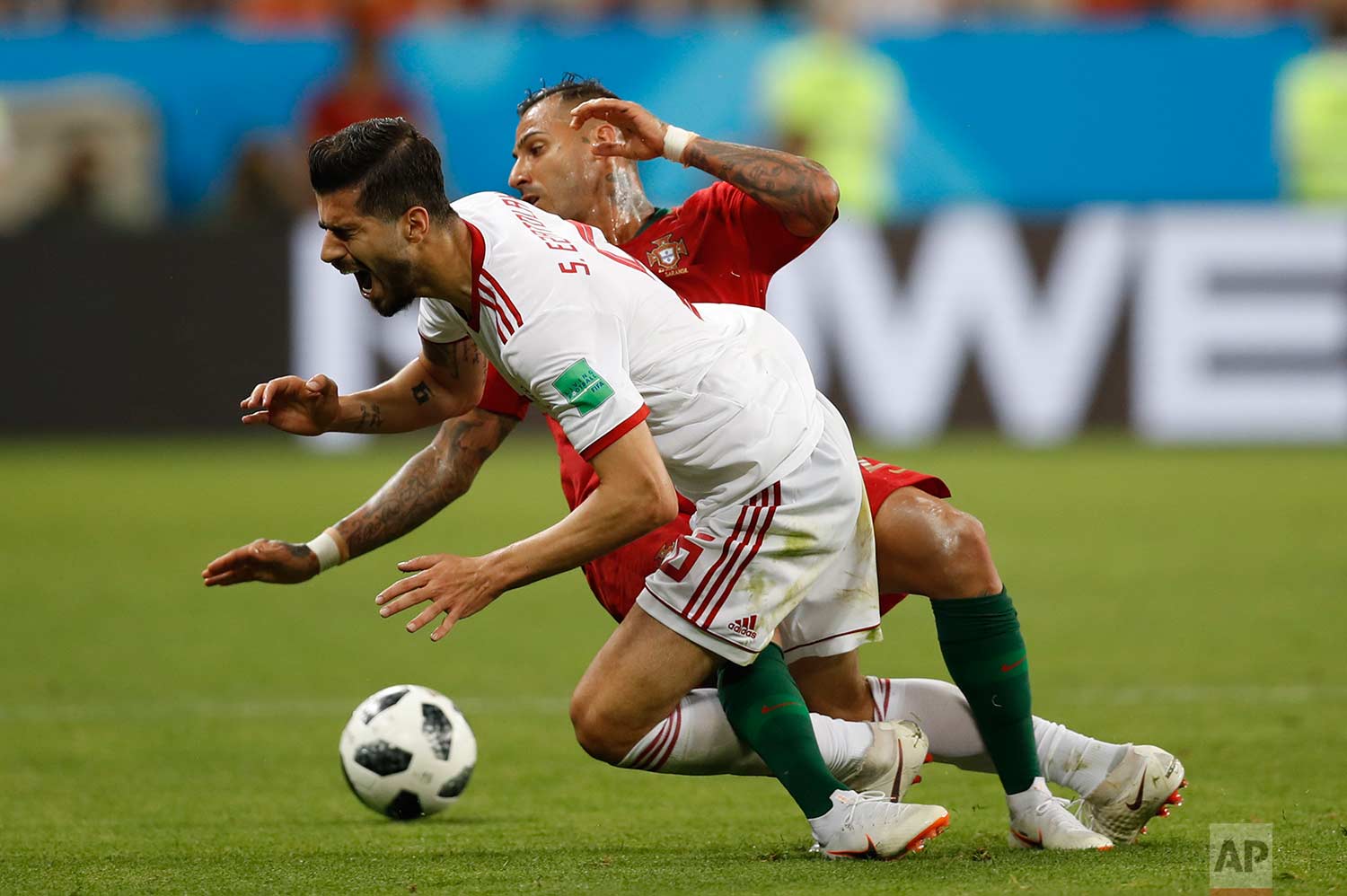  Iran's Saeid Ezatolahi front, falls as he is tackled by Portugal's Ricardo Quaresma during the group B match between Iran and Portugal at the 2018 soccer World Cup at the Mordovia Arena in Saransk, Russia, Monday, June 25, 2018. (AP Photo/Francisco 