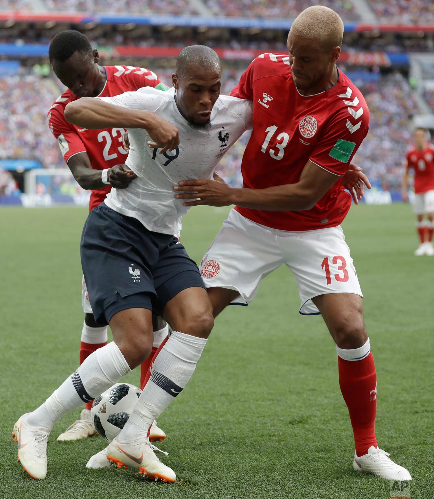  France's Djibril Sidibe, centre is tackled by Denmark's Pione Sisto, left, and Denmark's Mathias Jorgensen during the group C match between Denmark and France at the 2018 soccer World Cup at the Luzhniki Stadium in Moscow, Russia, Tuesday, June 26, 