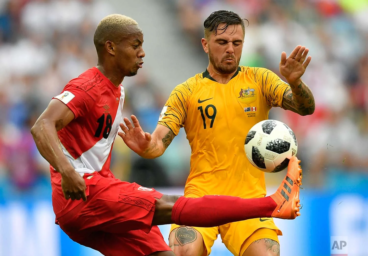 Peru's Andre Carrillo, left, and Australia's Joshua Risdon challenge for the ball during the group C match between Australia and Peru, at the 2018 soccer World Cup in the Fisht Stadium in Sochi, Russia, Tuesday, June 26, 2018. (AP Photo/Martin Meissner)