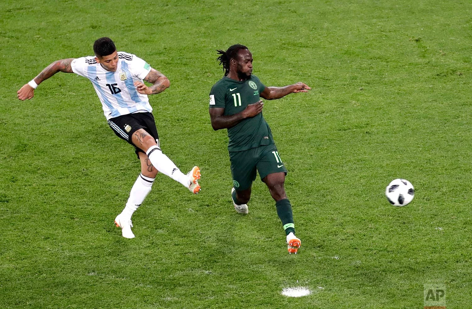 Argentina's Marcos Rojo, left, scores his side's second goal past Nigeria's Victor Moses during the group D match between Argentina and Nigeria, at the 2018 soccer World Cup in the St. Petersburg Stadium in St. Petersburg, Russia, Tuesday, June 26, 2018. (AP Photo/Michael Sohn)