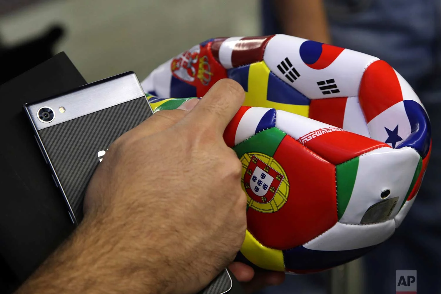 In this Saturday, June 16, 2018 photo, a supporter of Portugal holds a ball he bought at an airport shop at Sochi International Airport in Sochi, Russia. (AP Photo/Thanassis Stavrakis)