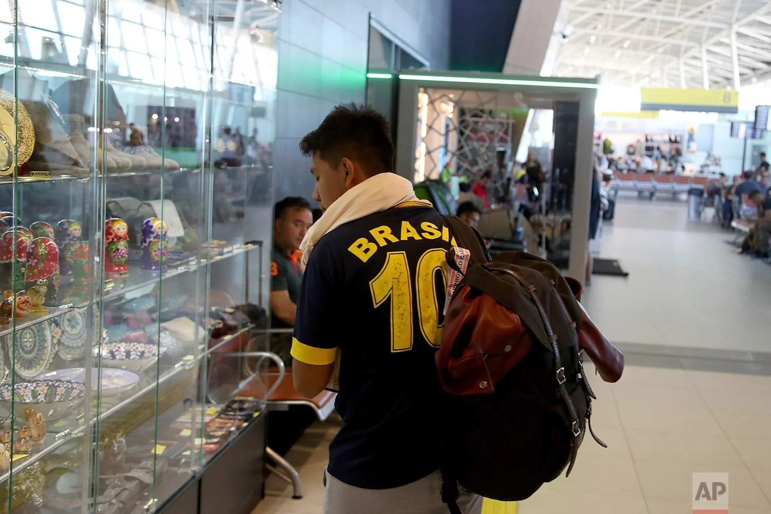 In this Friday, June 22, 2018 photo, a supporter of Brazil looks at souvenirs on sale at the Kazan International Airport in Kazan, Russia. (AP Photo/Thanassis Stavrakis)
