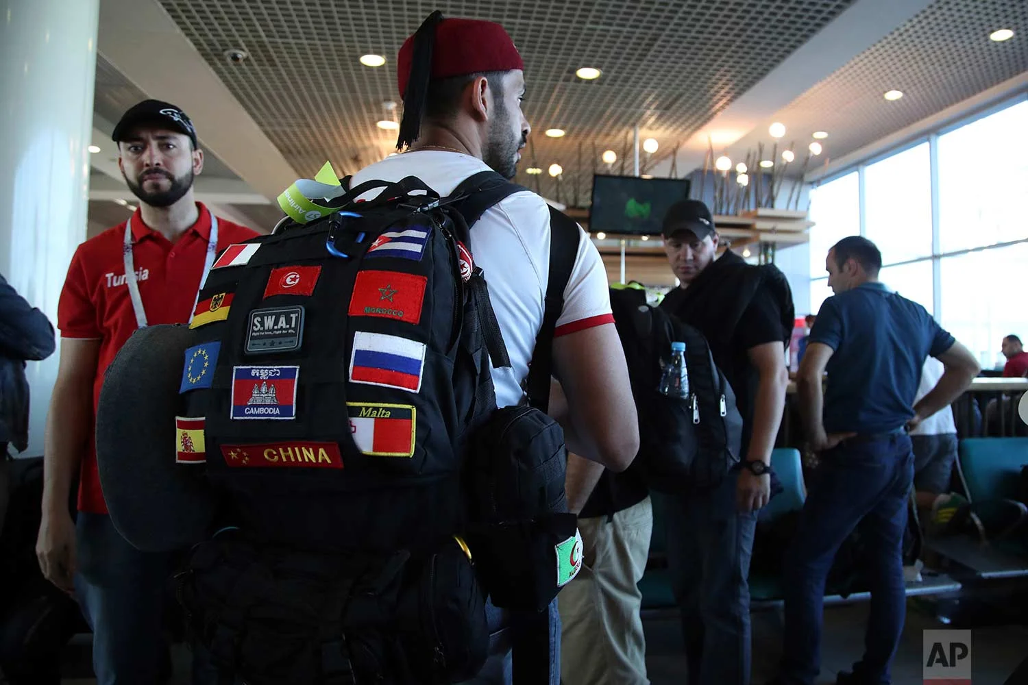 In this Saturday, June 16, 2018 photo, Tunisian fans wait to embark a plane at the Vnukovo International Airport, in Moscow, Russia. (AP Photo/Thanassis Stavrakis)