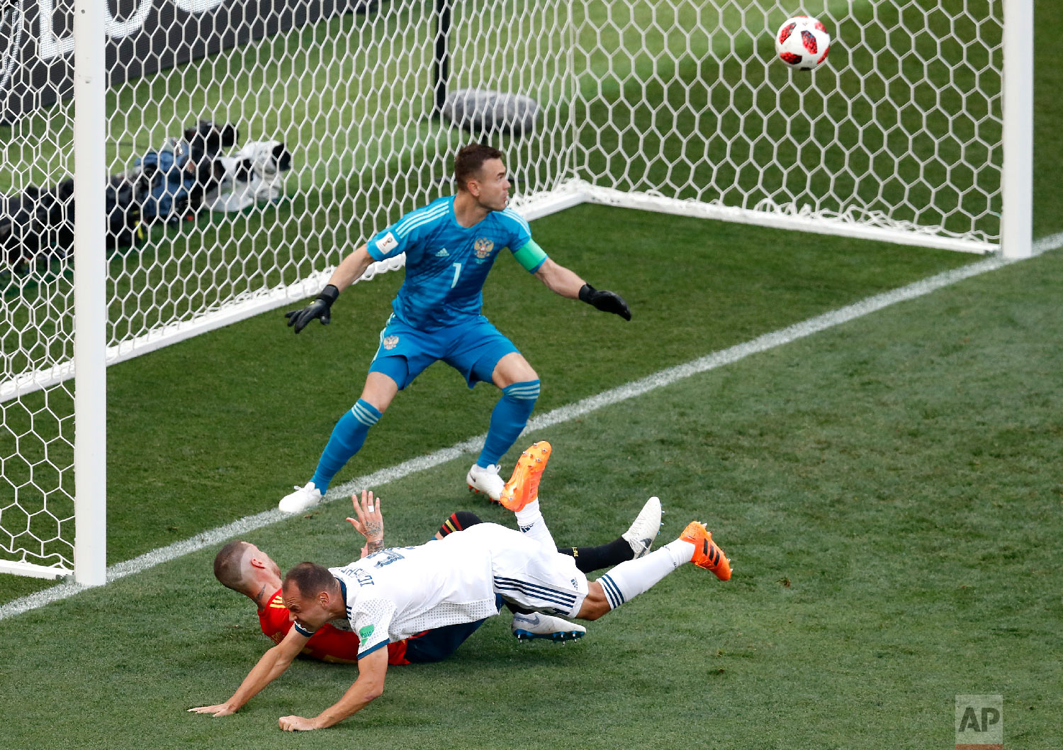 Russia's Sergei Ignashevich, front, scores an own goal during the round of 16 match between Spain and Russia at the 2018 soccer World Cup at the Luzhniki Stadium in Moscow, Russia, Sunday, July 1, 2018. (AP Photo/David Vincent)