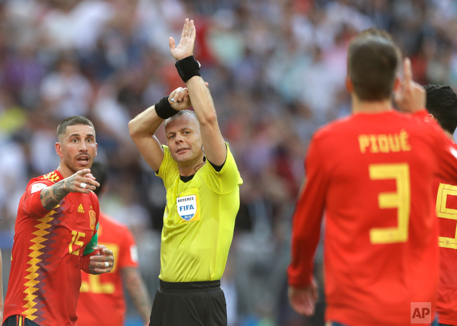 Referee Bjorn Kuipers from Netherlands indicates a handball by Spain's Gerard Pique, front, during the round of 16 match between Spain and Russia at the 2018 soccer World Cup at the Luzhniki Stadium in Moscow, Russia, Sunday, July 1, 2018. (AP Photo/Matthias Schrader)