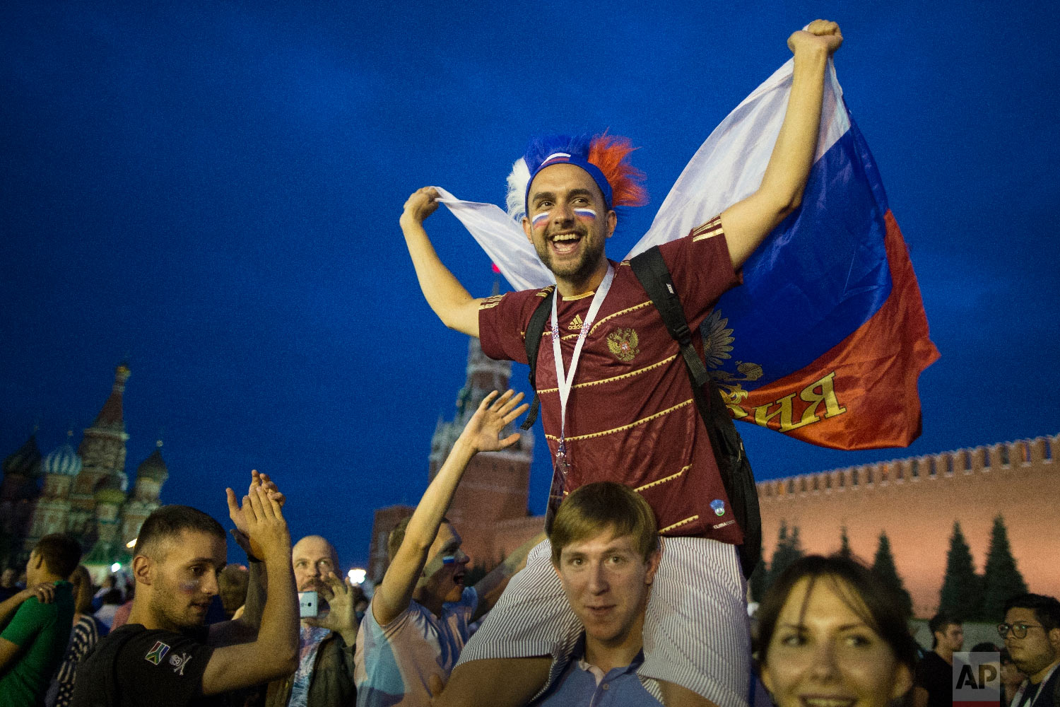 Russia soccer fans celebrate their team victory against Spain in Red Square after the round of 16 match between Spain and Russia at the 2018 soccer World Cup at the Luzhniki Stadium in Moscow, Russia, Sunday, July 1, 2018. Russia shocks Spain at the World Cup, beating the 2010 champion 4-3 in a penalty shootout after a 1-1 draw. (AP Photo/Alexander Zemlianichenko)