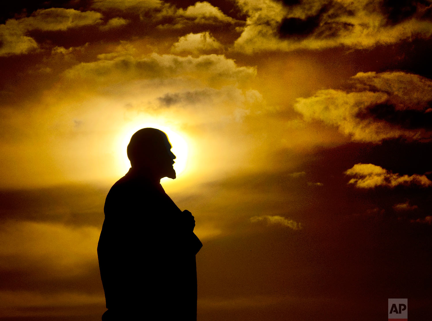  The sun sets behind a Lenin statue during the 2018 soccer World Cup in Podolsk, Russia on June 28, 2018. (AP Photo/Michael Probst) 
