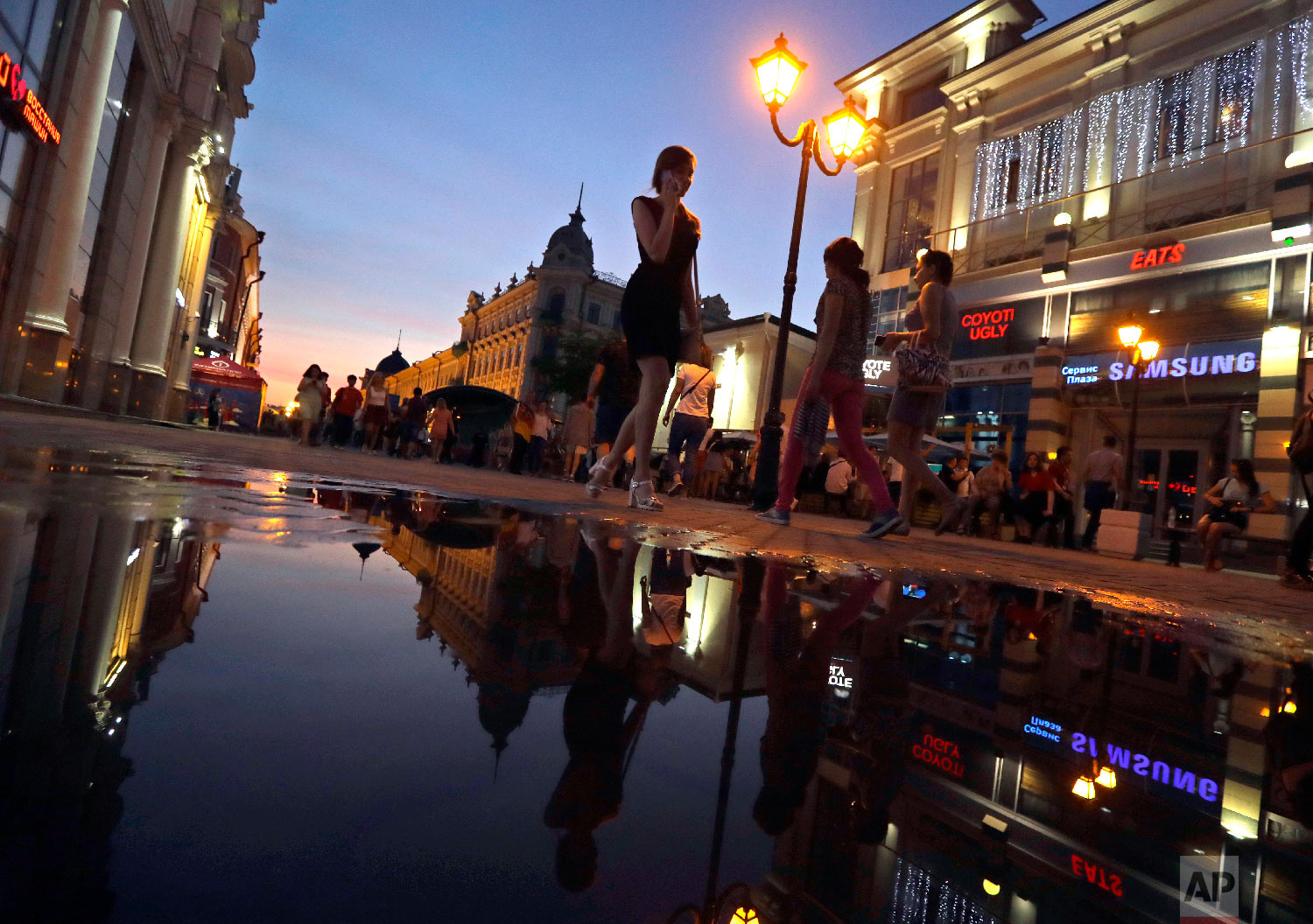  People walk at sunset during the 2018 soccer World Cup in downtown Kazan, Russia on June 26, 2018. (AP Photo/Sergei Grits) 