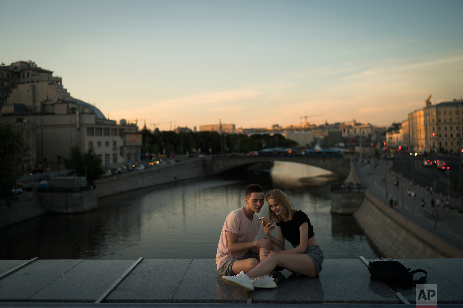 A young couple sit on a bridge as the sun sets during the 2018 soccer World Cup in Moscow, Russia on June 26, 2018. (AP Photo/Felipe Dana) 