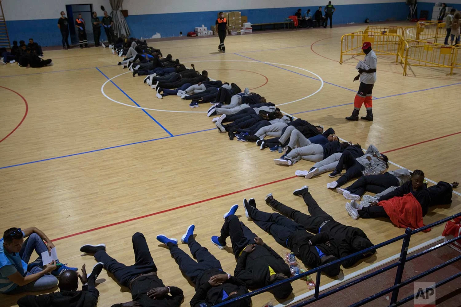 Migrants sleep at a makeshift emergency center for migrants at Barbate's municipal sports center, in the south of Spain, after being rescued by Spain's Maritime Rescue Service in the Strait of Gibraltar, Wednesday, June 27, 2018. Authorities in Southern Spain are setting up makeshift emergency centers for African migrants rescued in waters of the Mediterranean Sea as they hasten to cross into Europe. (AP Photo/Emilio Morenatti)