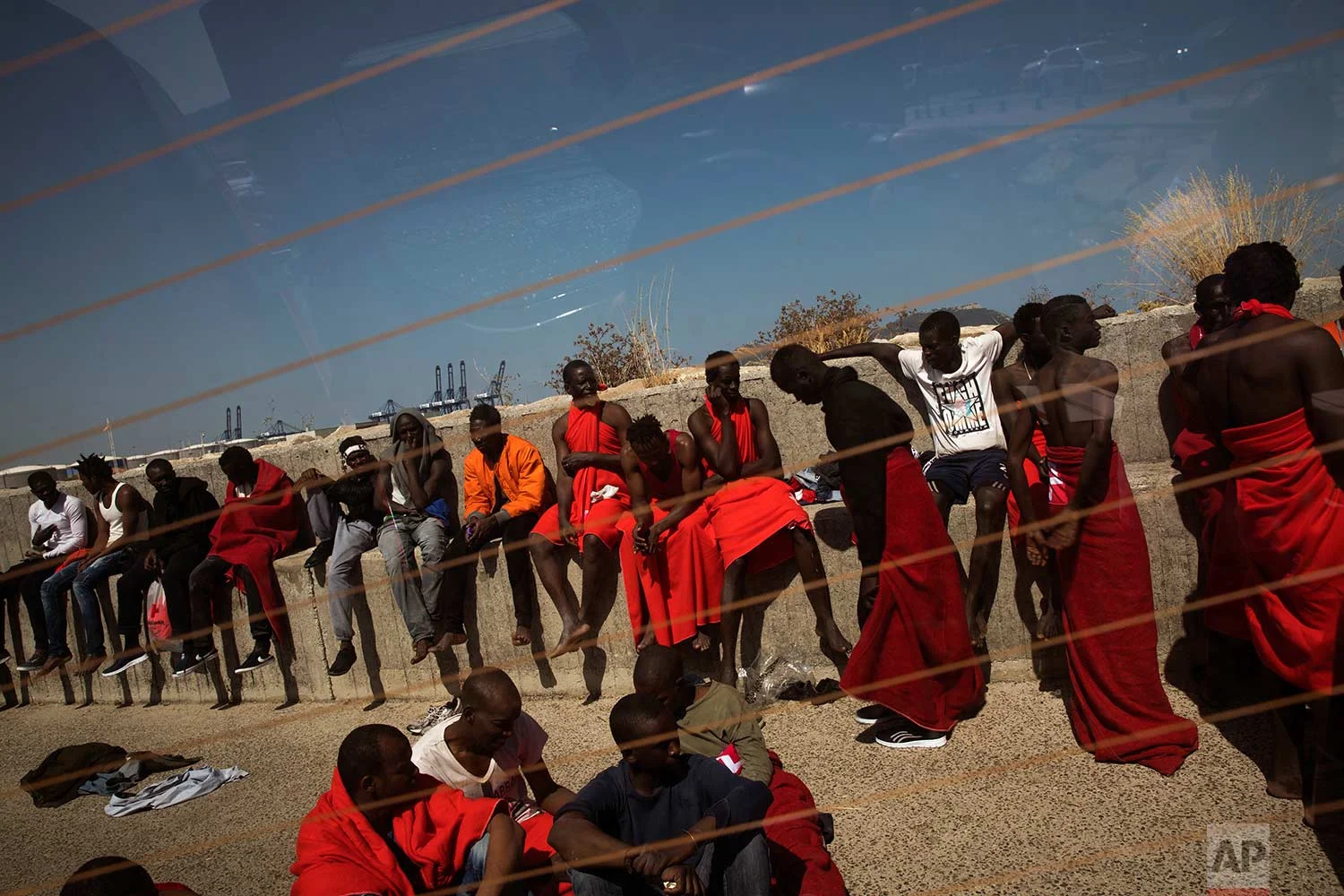 Migrants rest at the port of Algeciras, southern Spain, after being rescued in the Strait of Gibraltar, Tuesday, Jun. 26, 2018. Spain's Maritime Rescue Service says it has picked up just over 400 people from the Mediterranean as migrants hasten to reach Spain from North Africa while the weather remains fair. (AP Photo/Emilio Morenatti)