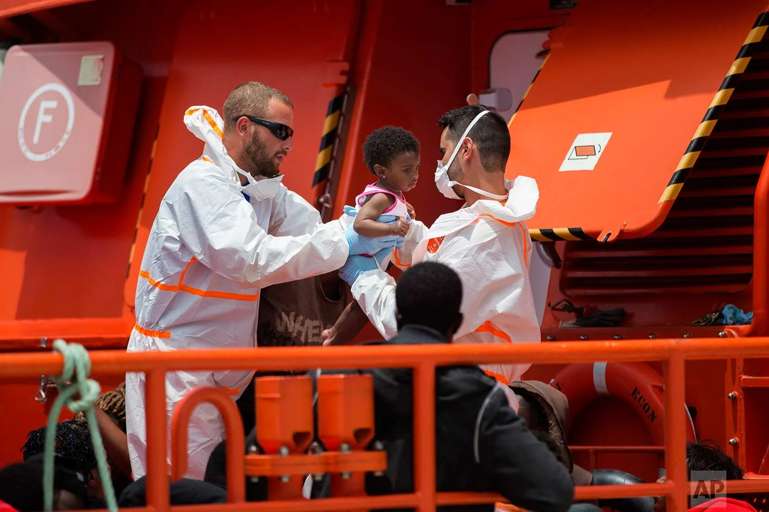 A baby is taken by rescue members at the port of Barbate, southern Spain, after being rescued by Spain's Maritime Rescue Service in the Strait of Gibraltar, Wednesday, June 27, 2018. (AP Photo/Emilio Morenatti)