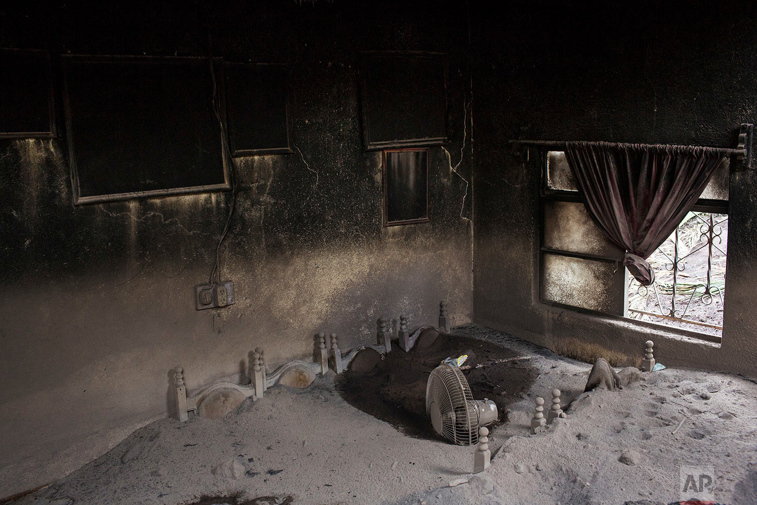  A dining room is interred in volcanic ash spewed by the Volcano of Fire in San Miguel Los Lotes, Guatemala, June 8, 2018. (AP Photo/Rodrigo Abd) 