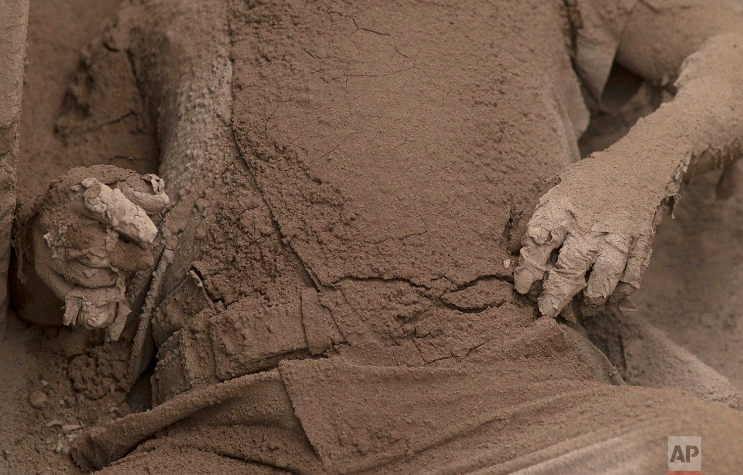  A body is covered in volcanic ash spewed by the Volcano of Fire in Escuintla, Guatemala, June 4, 2018. (AP Photo/Luis Soto) 