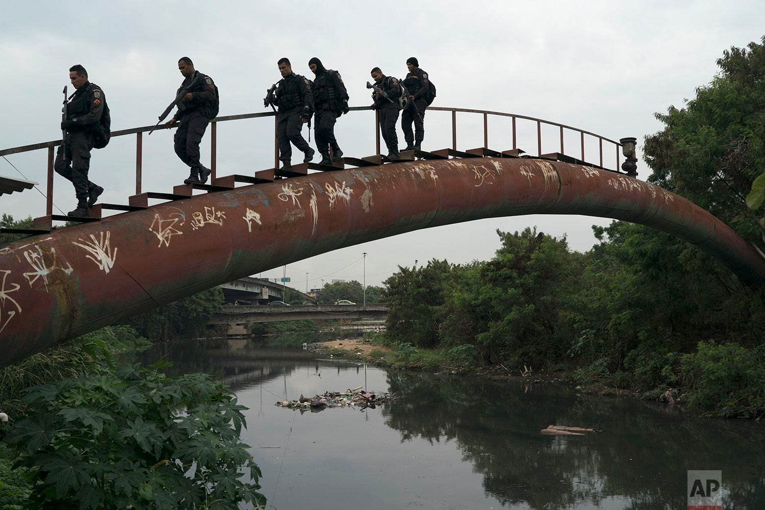  Police walk over a water pipe during a security operation in the City of God slum of Rio de Janeiro, Brazil, June 7, 2018. (AP Photo/Leo Correa) 