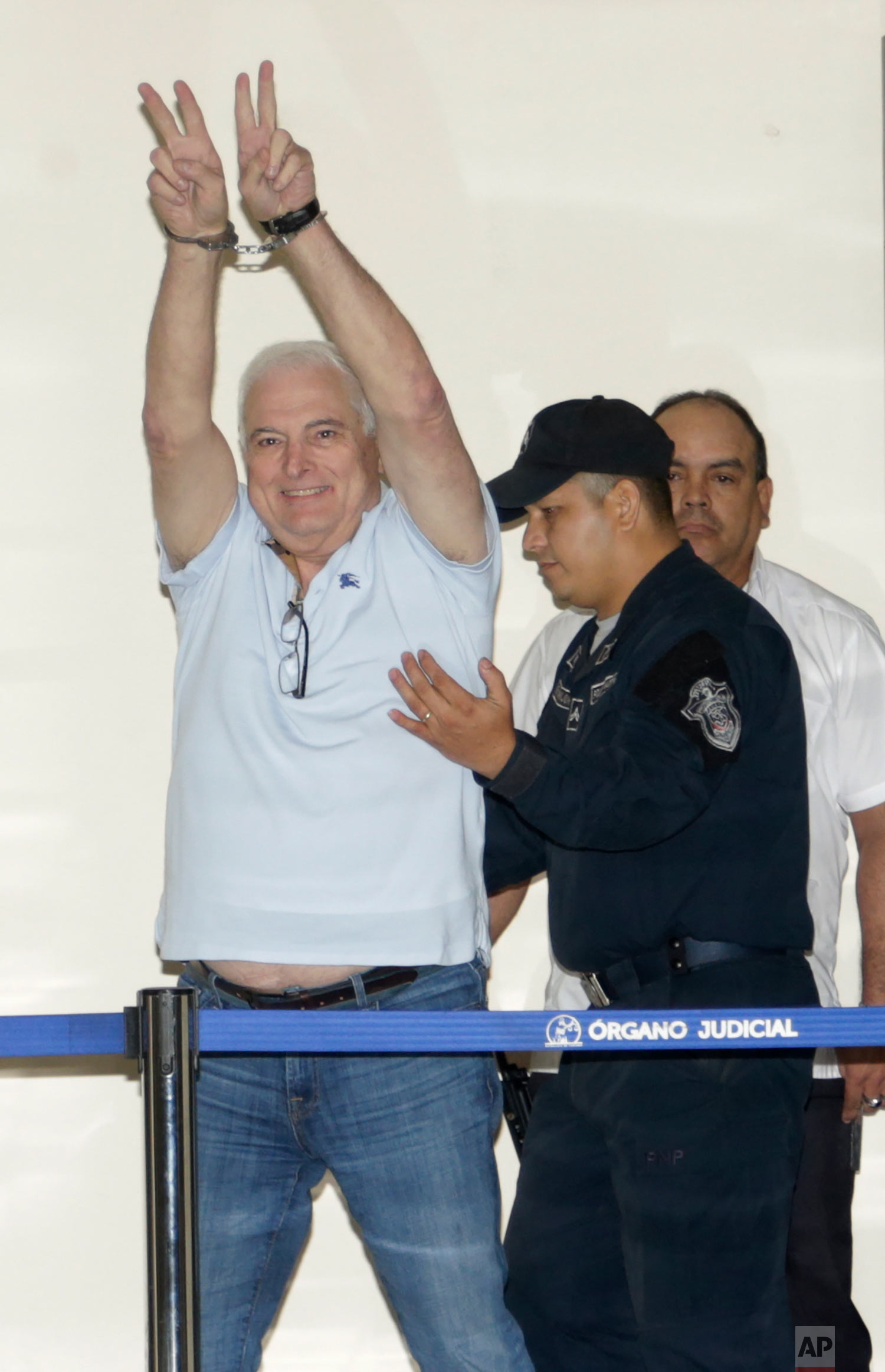  Former Panamanian President Ricardo Martinelli gestures victory from his handcuffs while escorted away from his hearing at the Supreme Court in Panama City, June 11, 2018. Martinelli returned to Panama to face political espionage and embezzlement ch