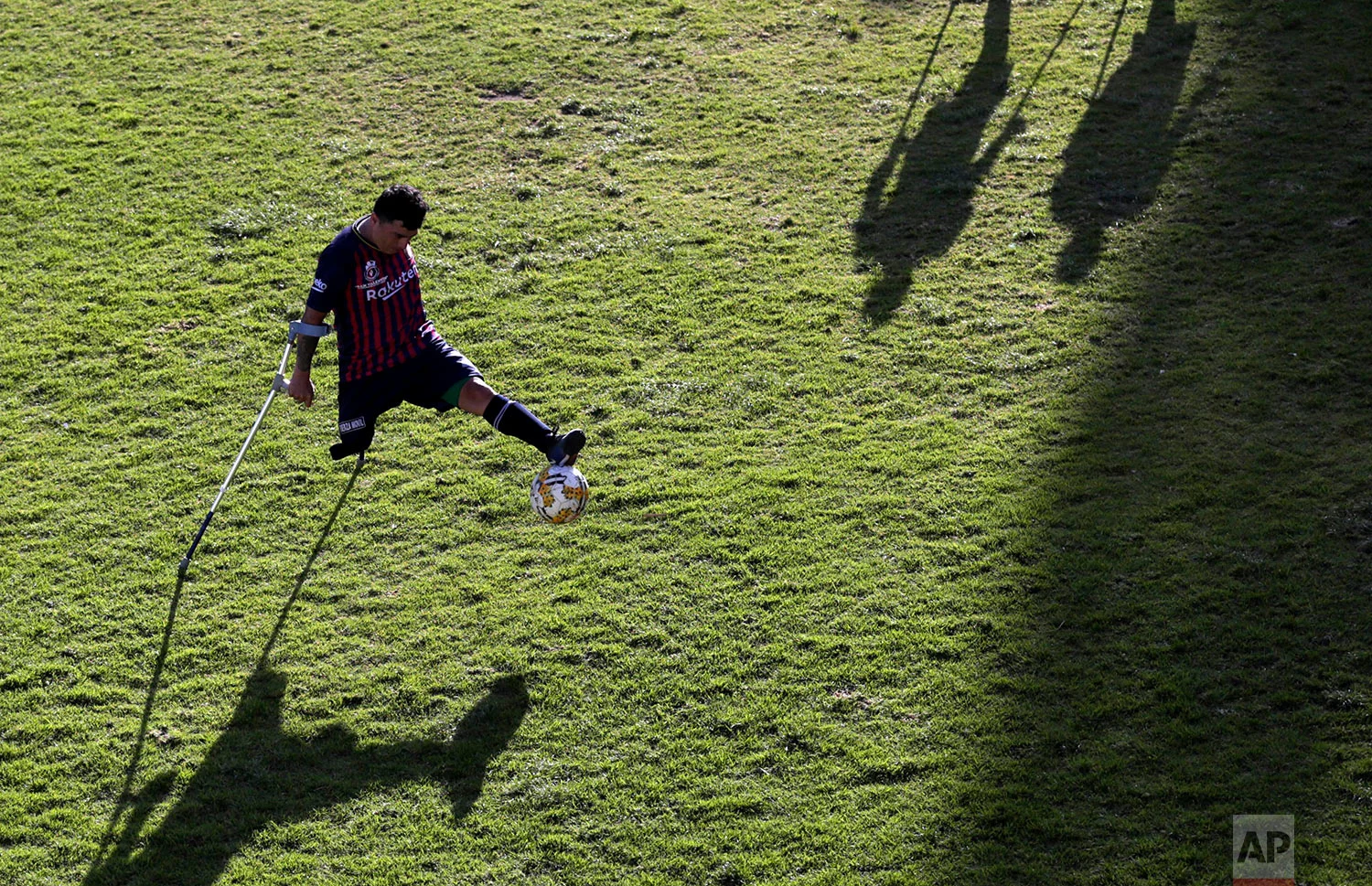 Robin Burbano controls the ball on crutches, during a game against El Empalme at a national soccer tournament for players with amputated limbs, in Quito, Ecuador, June 9, 2018. (AP Photo/Dolores Ochoa)