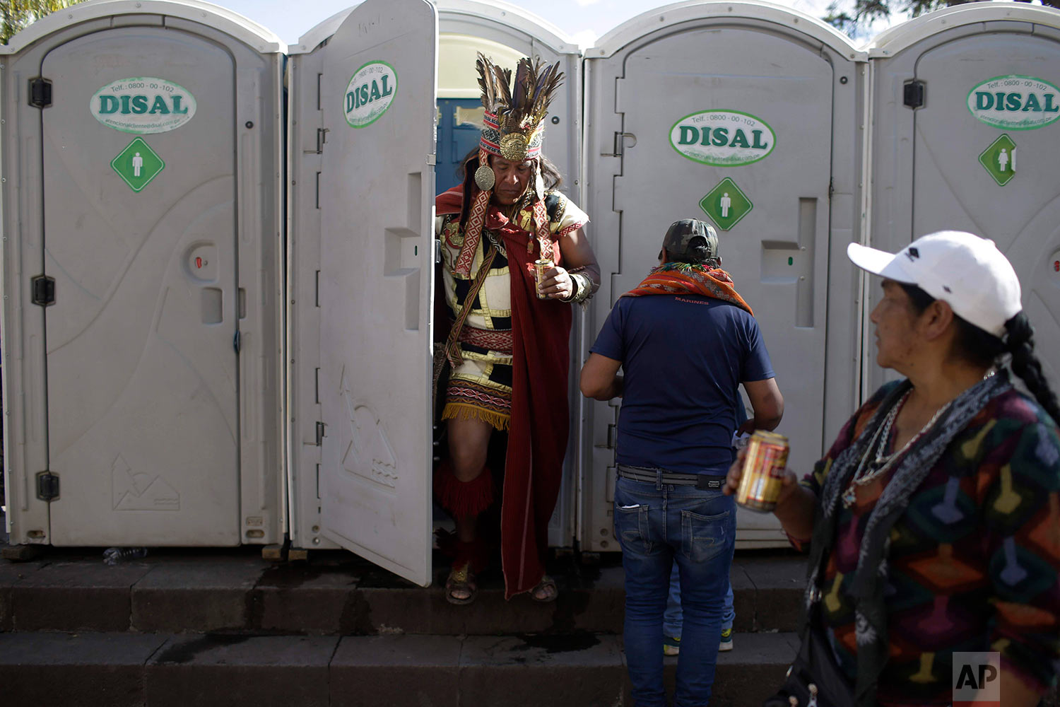  A man dressed a the Inca Emperor Atahualpa leaves of a porta-pottie as he holds a beer, in Cuzco, Peru, June 23, 2018, during the Inti Raymi, the Festival of the Sun. (AP Photo/Martin Mejia) 