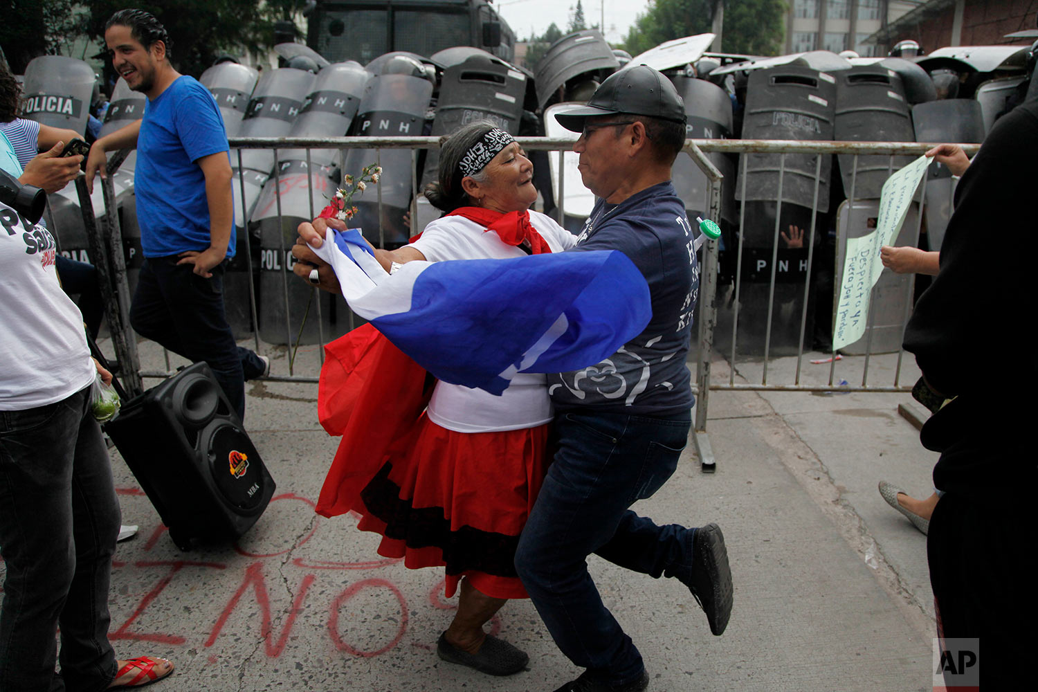  A couple dances in front of a police barricade during a protest in Tegucigalpa, Honduras, June 2, 2018, during a protest against Juan Orlando Hernandez' government before they were forcibly removed by military and police. (AP Photo/Fernando Antonio)