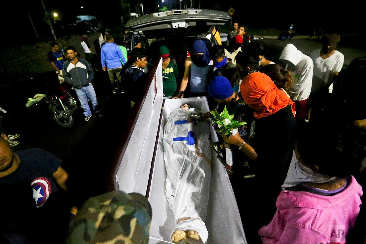 The body of 19-year-old Chester Chavarria is surrounded by his friends outside the Autonomous University of Nicaragua, in Managua, June 8, 2018. Chavarria died after being shot several times while guarding a barricade during a protest against the government. (AP Photo/Esteban Felix)