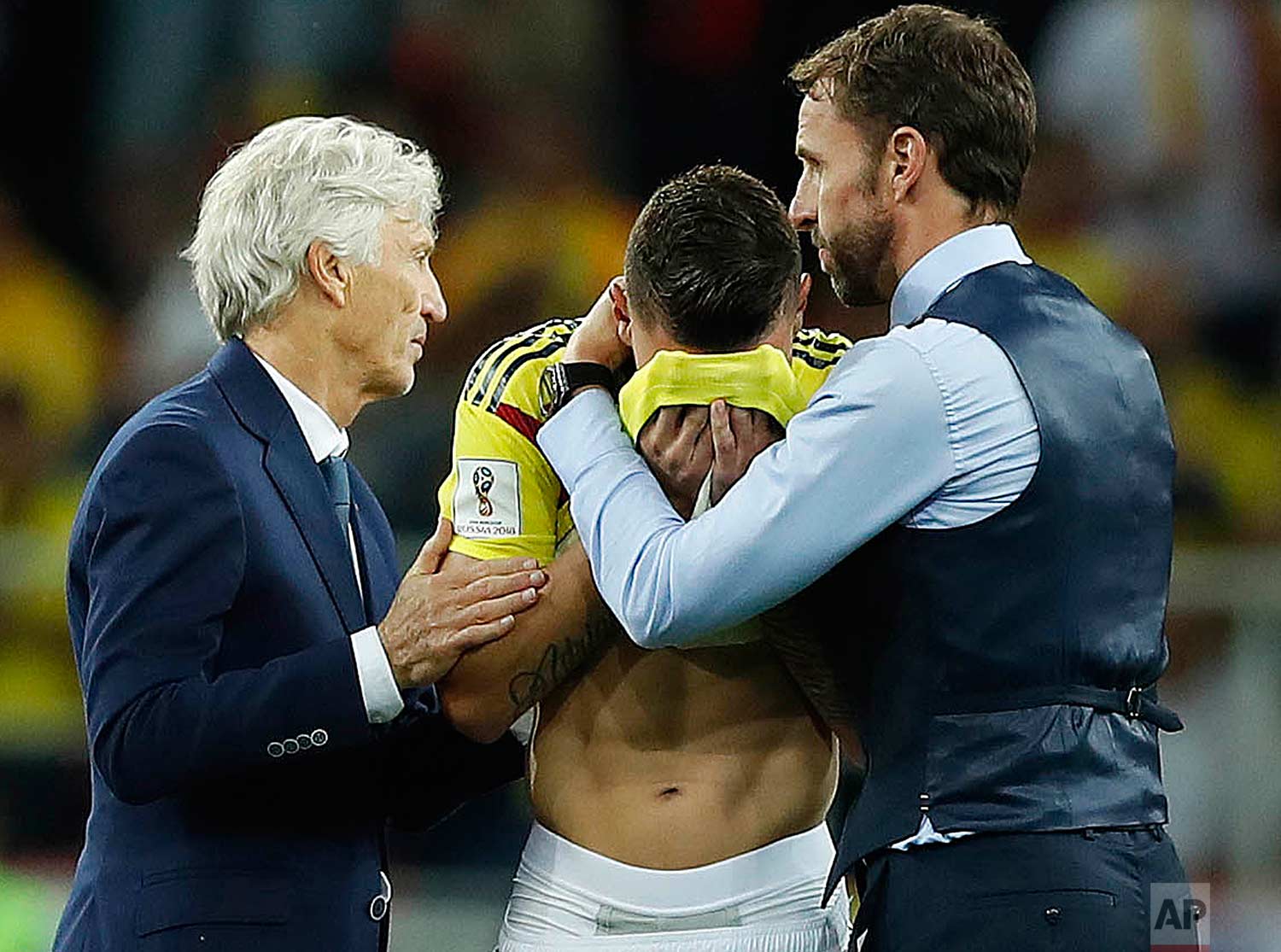 Colombia head coach Jose Pekerman, left, and England head coach Gareth Southgate, right, comfort Colombia's Mateus Uribe after the round of 16 match between Colombia and England at the 2018 soccer World Cup in the Spartak Stadium, in Moscow, Russia, Tuesday, July 3, 2018. (AP Photo/Alastair Grant)