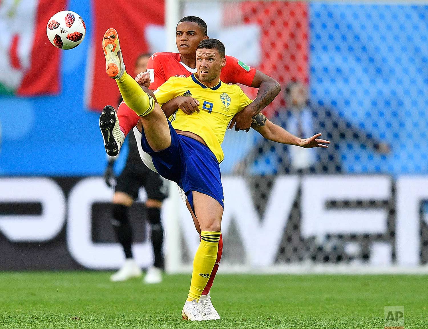 Switzerland's Manuel Akanji, rear, and Sweden's Marcus Berg challenge for the ball during the round of 16 match between Switzerland and Sweden at the 2018 soccer World Cup in the St. Petersburg Stadium, in St. Petersburg, Russia, Tuesday, July 3, 2018. (AP Photo/Martin Meissner)