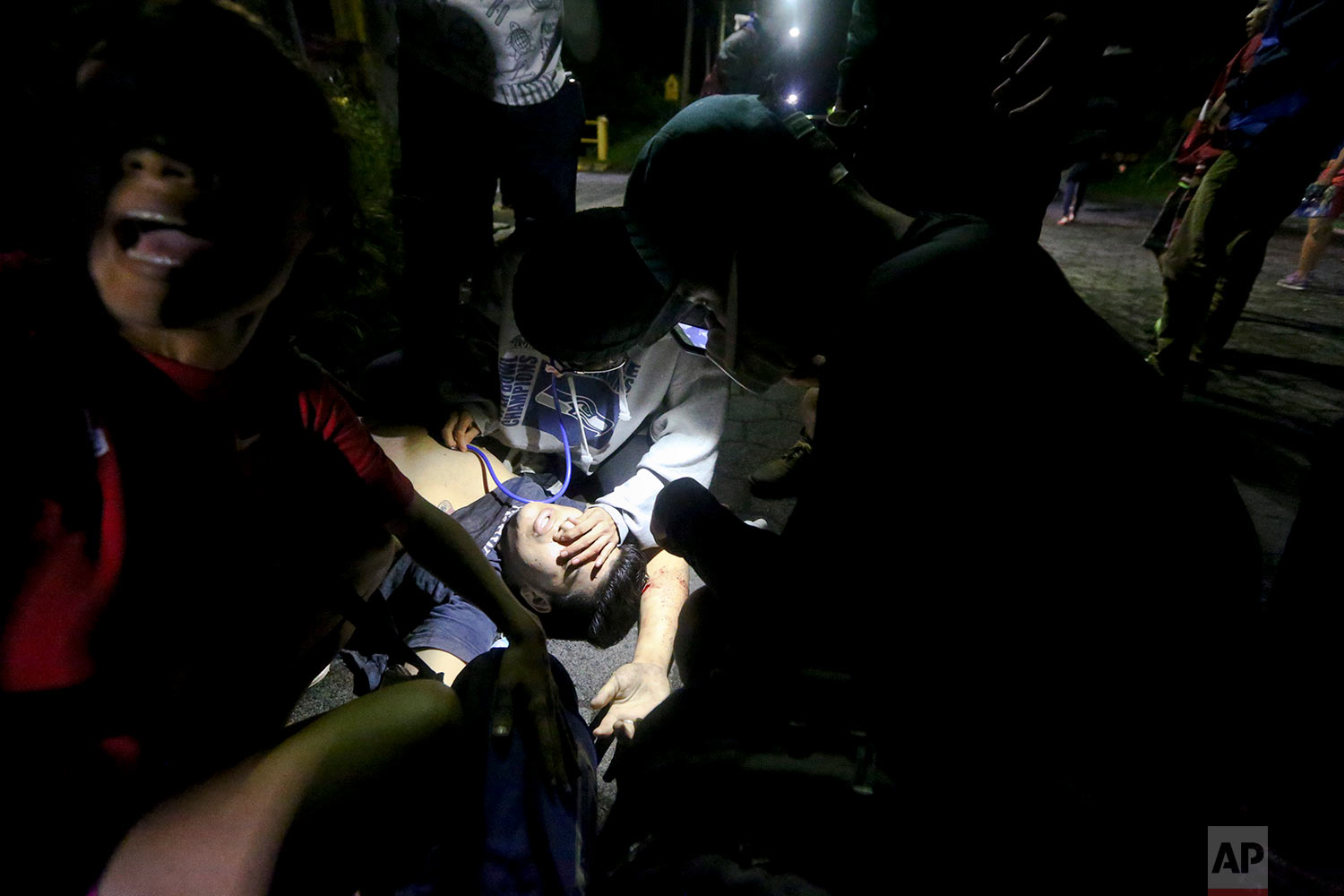  In this June 7, 2018 photo, high school student Chester Chavarria gets first aid by university students after he was shot at a barricade set up behind an entrance to the Autonomous University of Nicaragua, where anti-government students have barrica