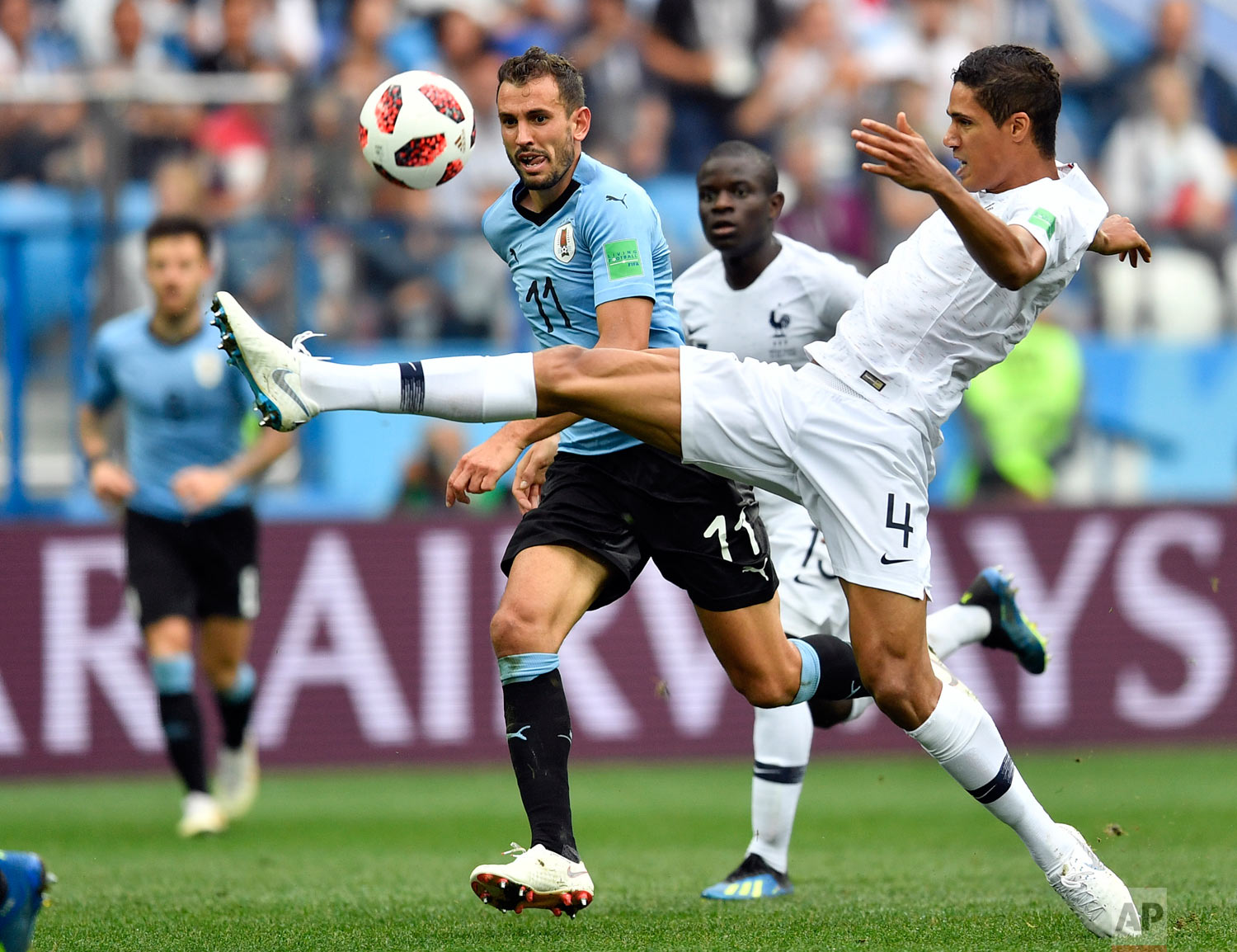 France's Raphael Varane, right, is challenged by Uruguay's Cristhian Stuani during the quarterfinal match between Uruguay and France at the 2018 soccer World Cup in the Nizhny Novgorod Stadium, in Nizhny Novgorod, Russia, Friday, July 6, 2018. (AP Photo/Martin Meissner)