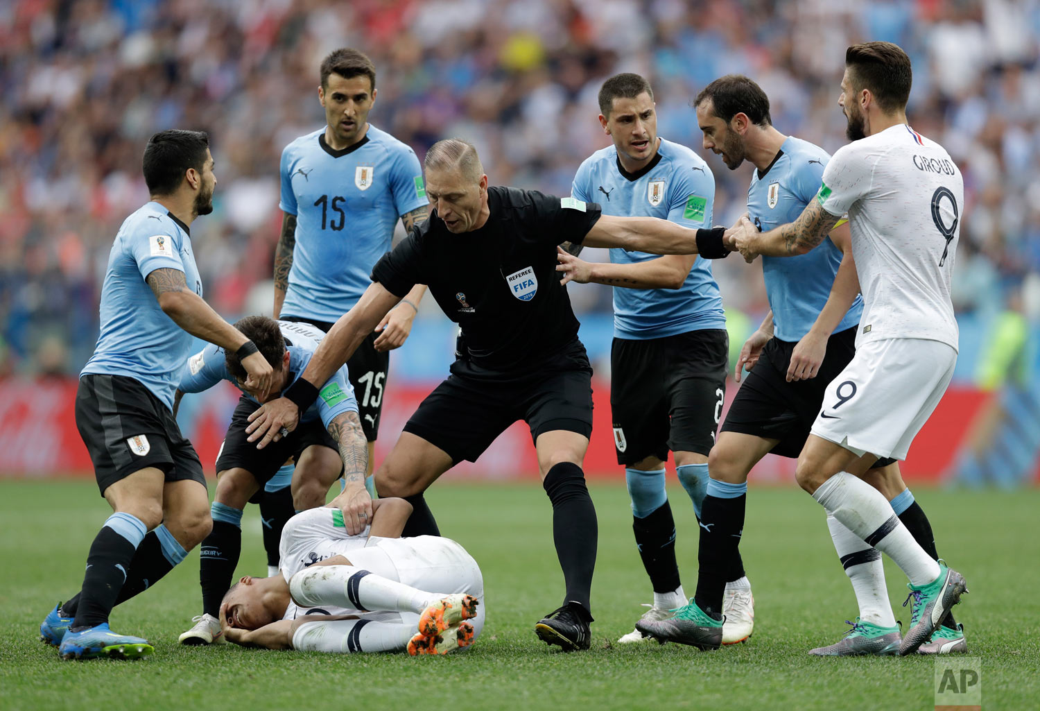  Uruguay players protest to referee Nestor Pitana of Argentina that France's Kylian Mbappe, on the ground, is overreacting after taking a dive during the quarterfinal match between Uruguay and France at the 2018 soccer World Cup in the Nizhny Novgoro