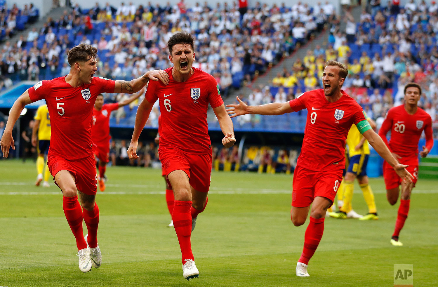  England's Harry Maguire, center, celebrates with his teammates after scoring his side opening goal during the quarterfinal match between Sweden and England at the 2018 soccer World Cup in the Samara Arena, in Samara, Russia, Saturday, July 7, 2018. 